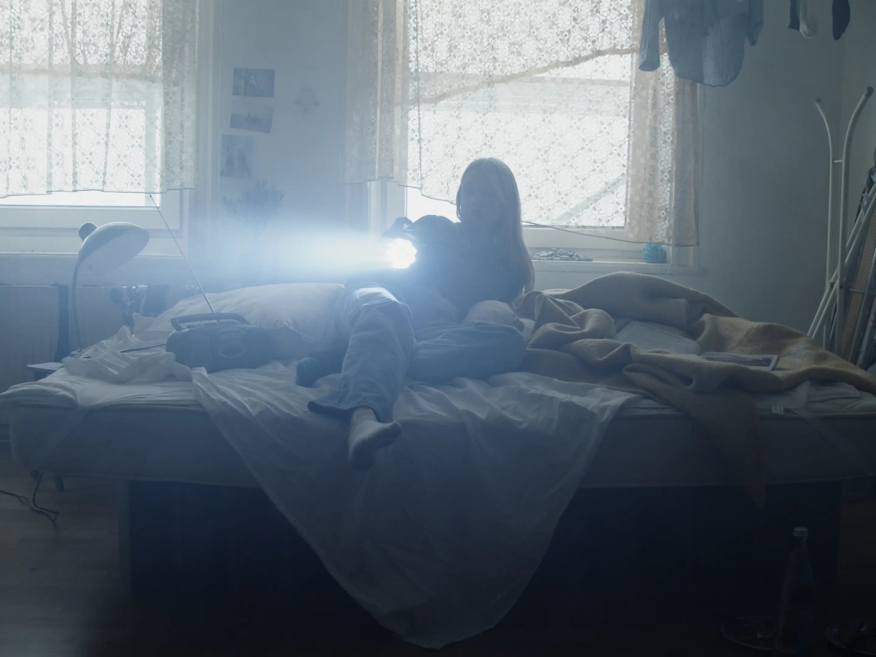 two young people lying on a bed